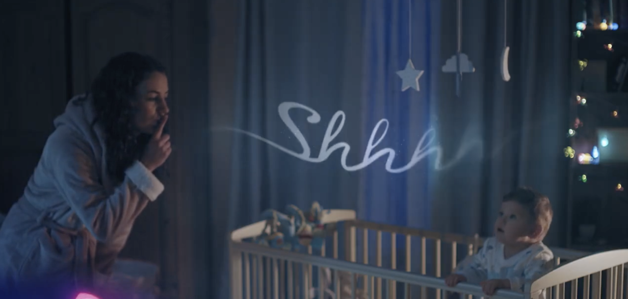 Still from the TV ad showing baby in cot and mum saying shhh.