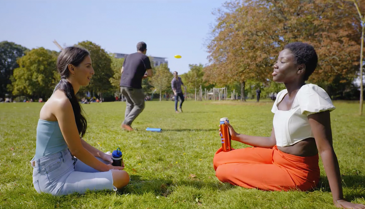 Photo of 2 women in a park drinking from ION8 bottles.