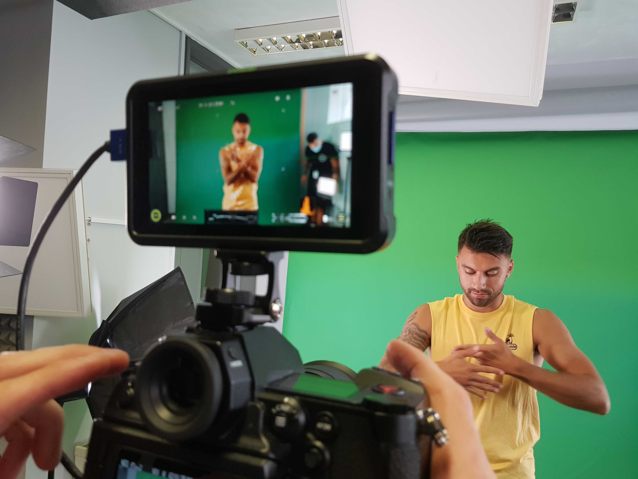 A person capturing footage in front of a green screen for post-production editing.