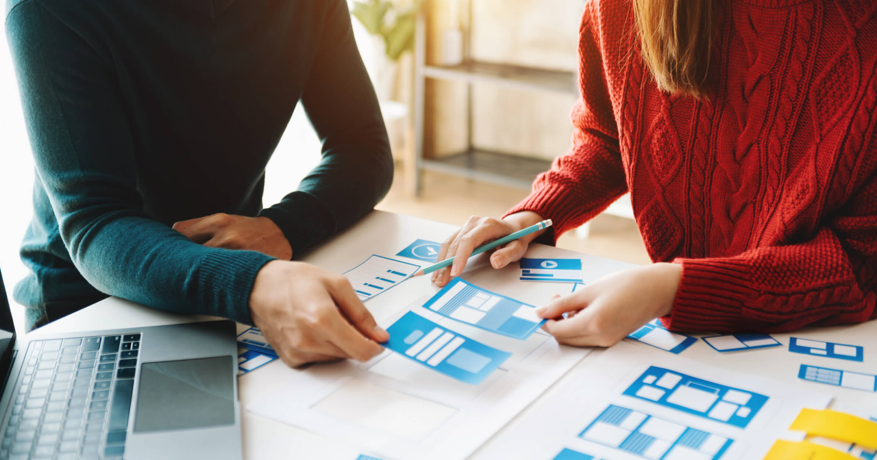 Two people making early wireframing decisions on an mobile application project.