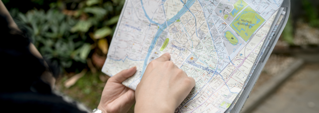 Map in hand, person navigates city.