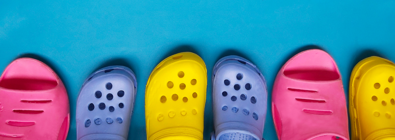 Five vibrant crocs arranged on a blue backdrop, showcasing a burst of colours.