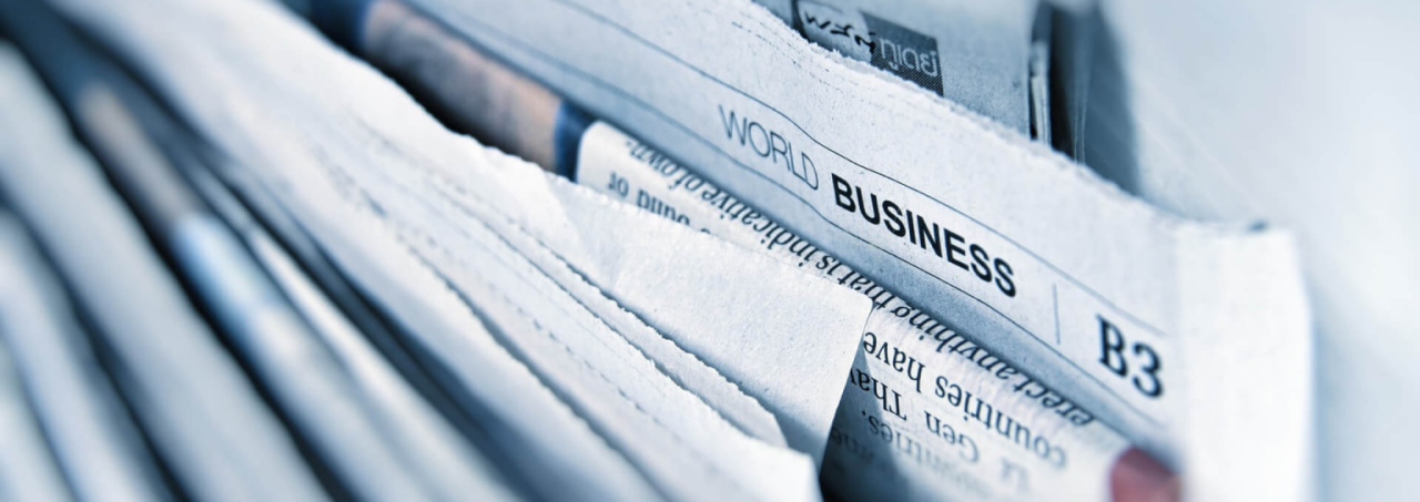 Closeup of newspaper with headlines and text.